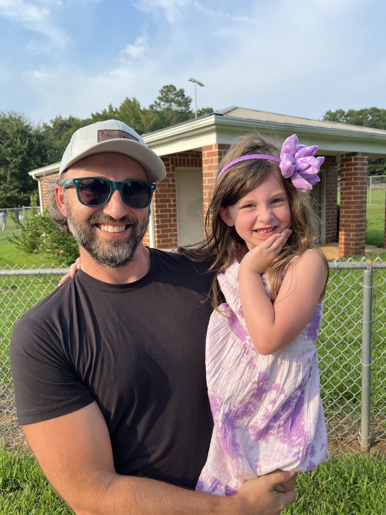 An adult takes a photo with a rising kindergartener at a kindergarten welcome event.