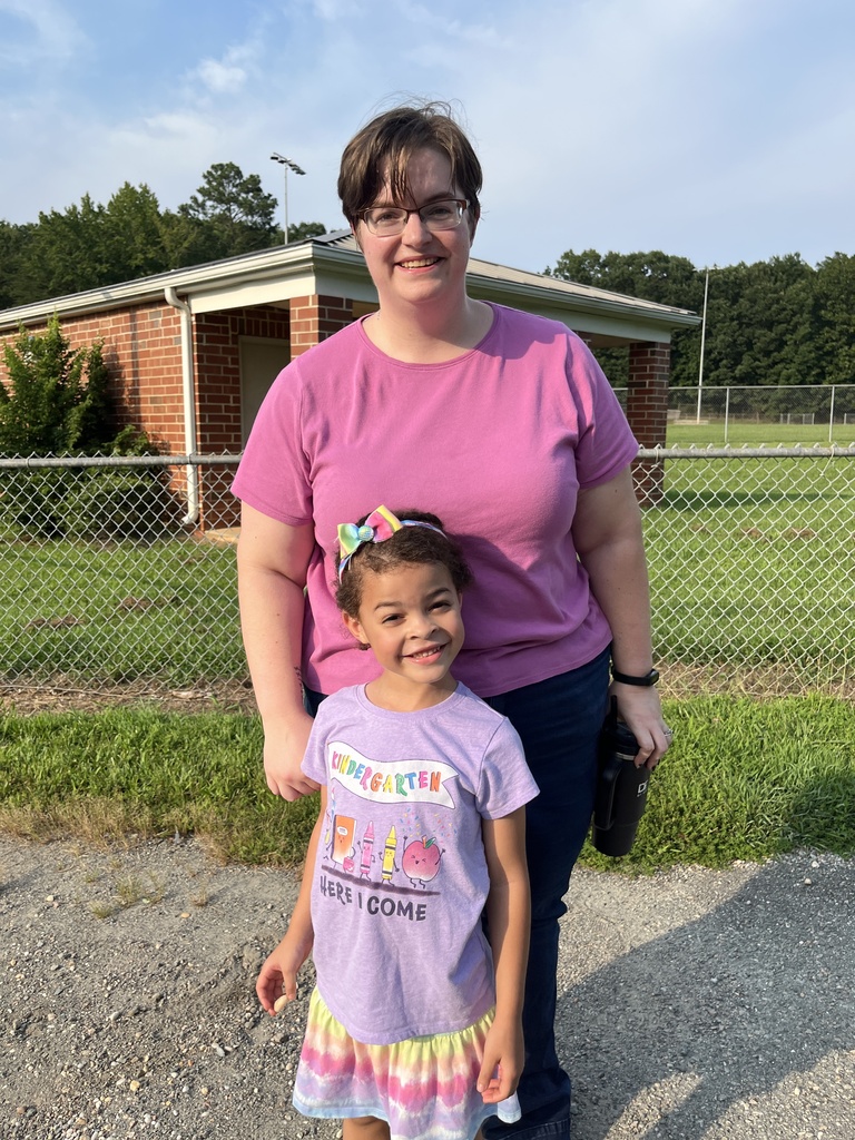 An adult takes a photo with a rising kindergartener at a kindergarten welcome event.