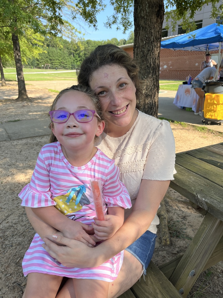 An adult and child pose for a photo at a kindergarten welcome event.