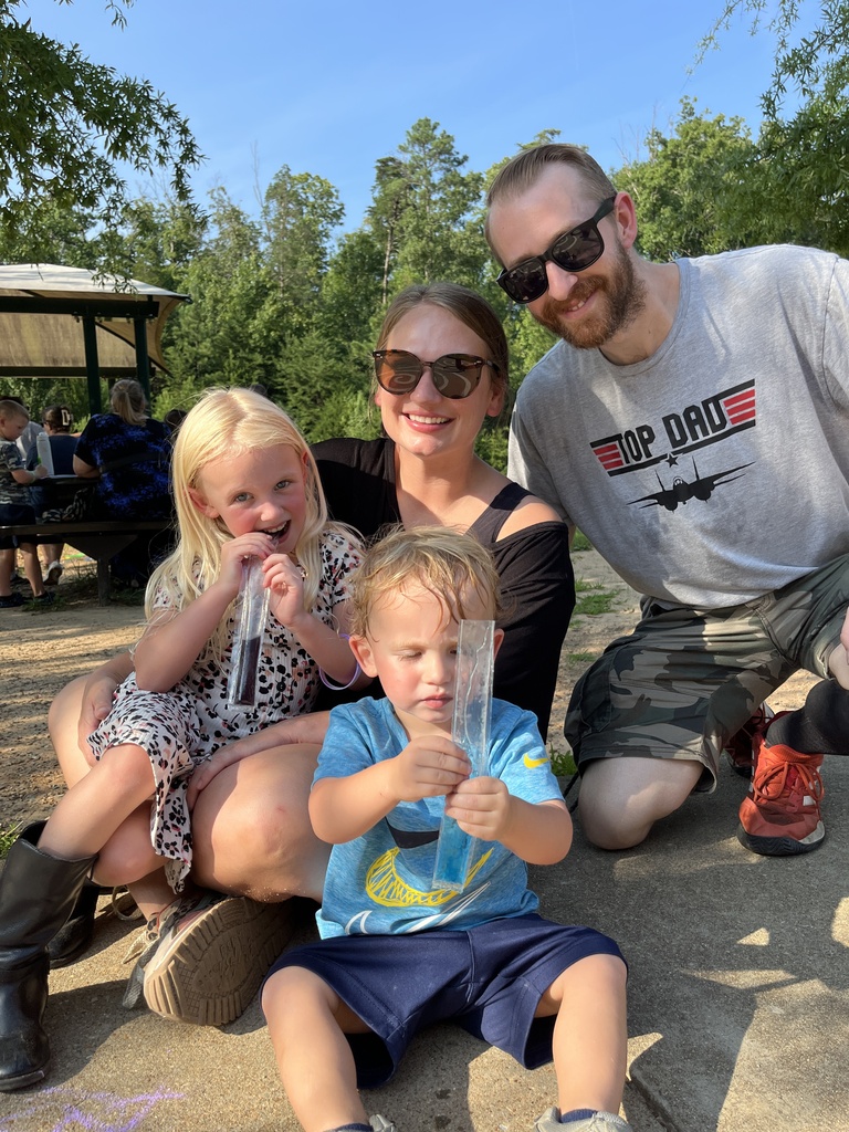 Two adults and two children pose for a photo at a kindergarten welcome event.