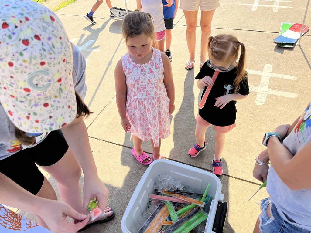 Two children get popsicles at a kindergarten welcome event.