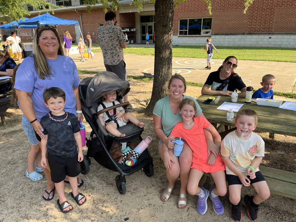 Three adults and five children pose for a photo at a kindergarten welcome event.