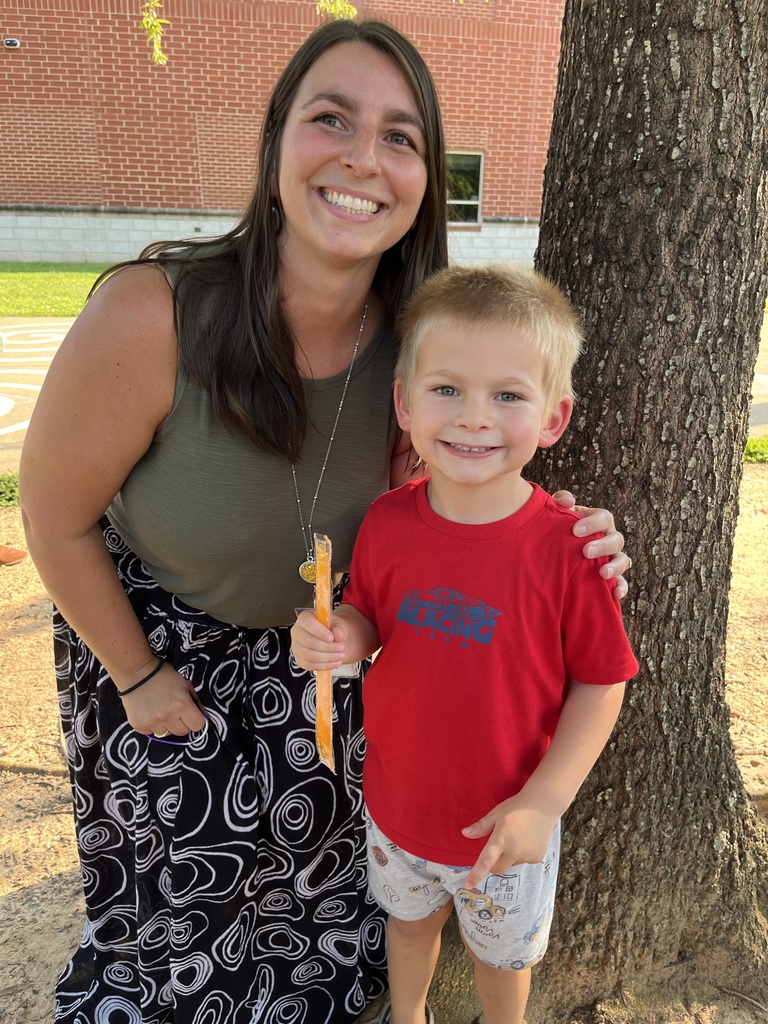 An adult and child pose for a photo at a kindergarten welcome event.