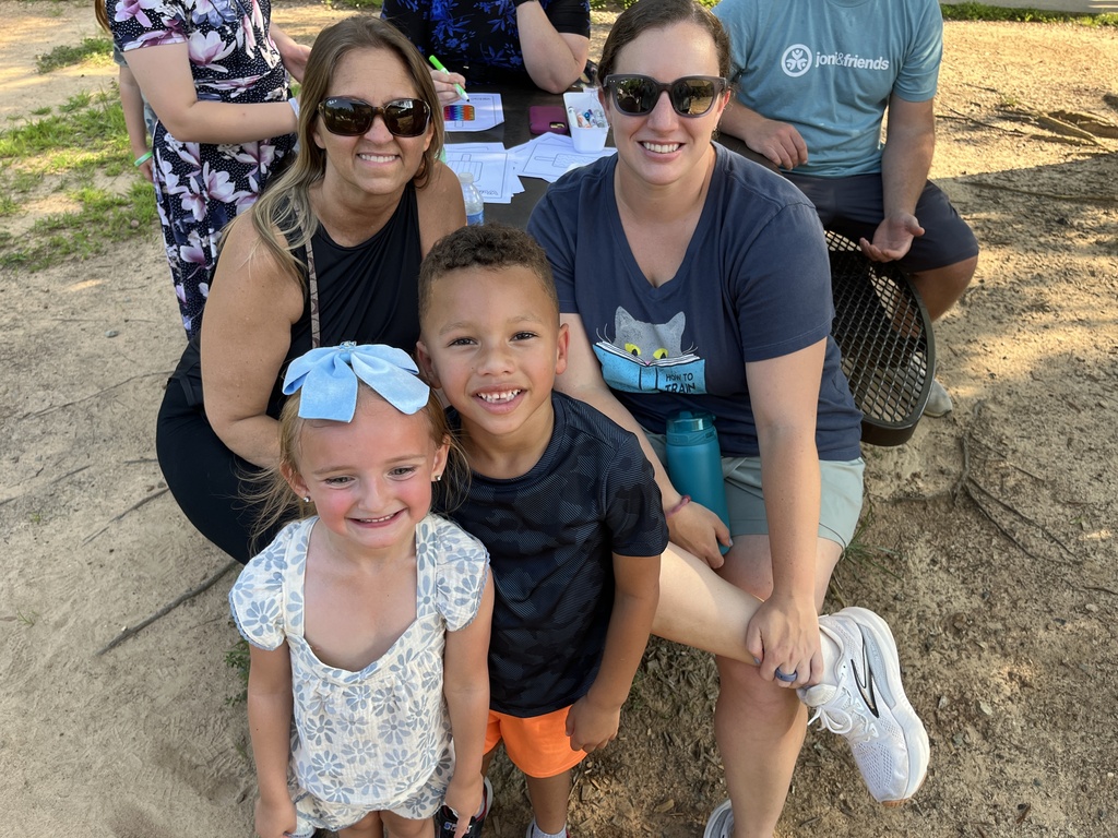 Two adults and two children pose for a photo at a kindergarten welcome event.