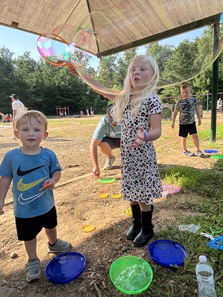 Two children play with bubbles at a kindergarten welcome event.