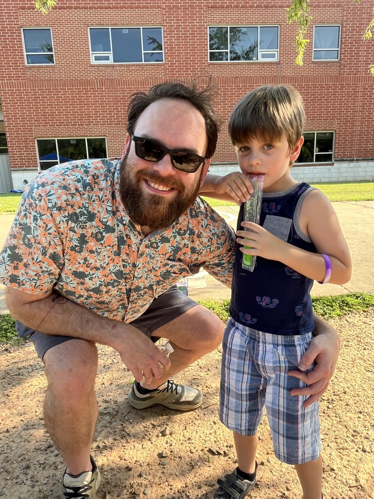 An adult and child pose for a photo at a kindergarten welcome event.