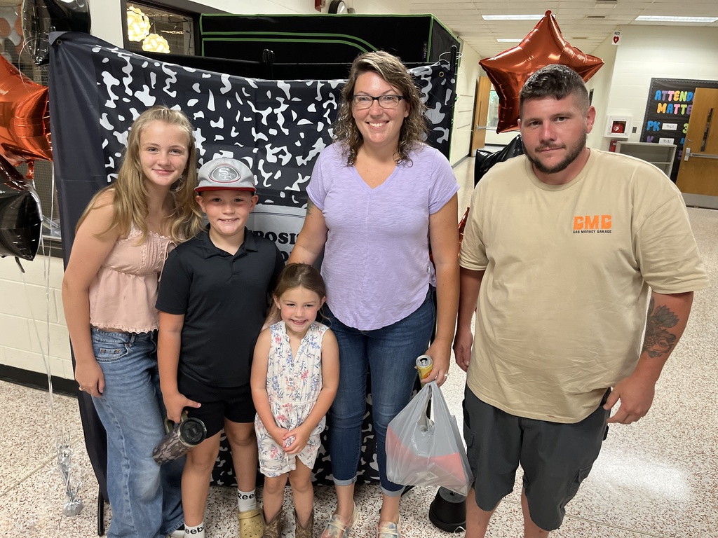 Two adults and three  children pose for a photo at a preschool information night.