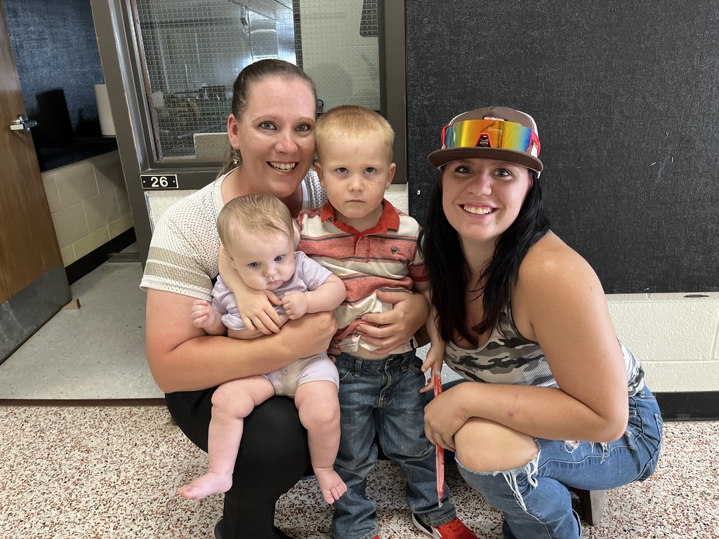 Two adults and two children pose for a photo at a preschool information night.