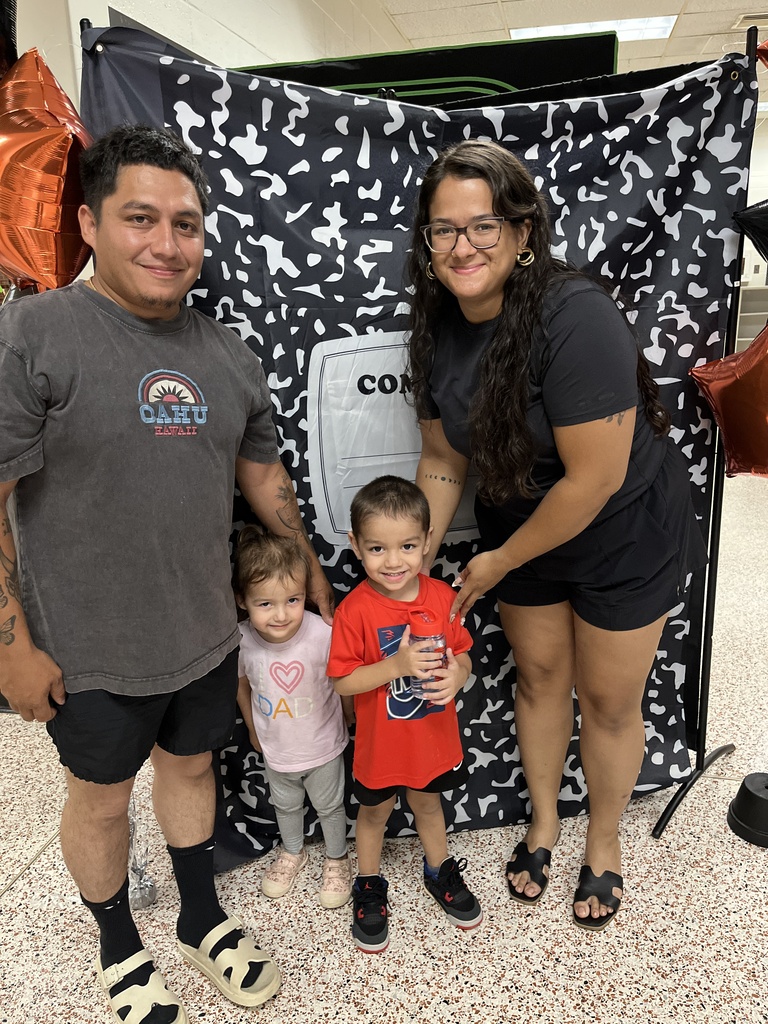 Two adults and two children pose for a photo at a preschool information night.