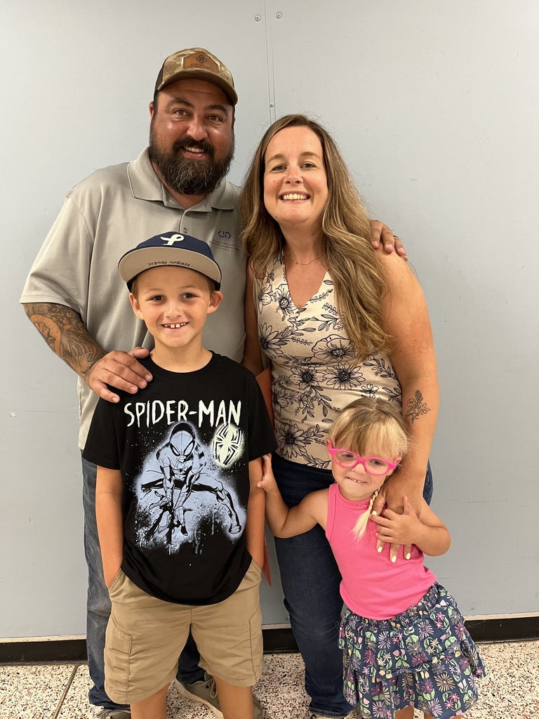 Two adults and two children pose for a photo at a preschool information night.