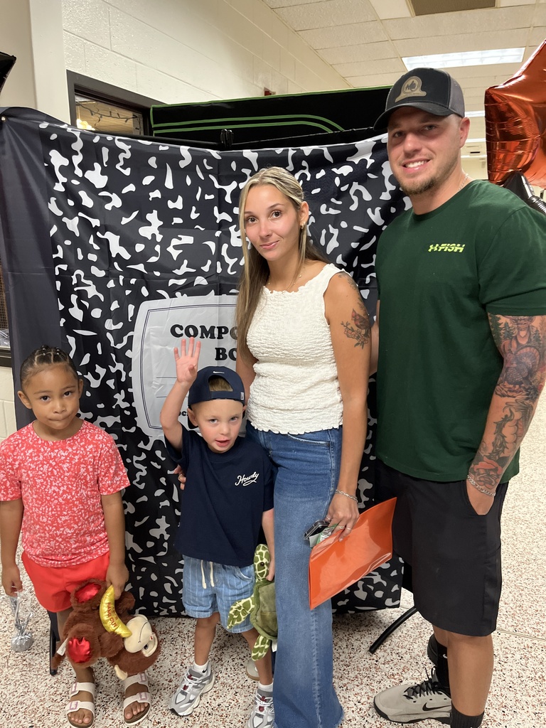 Two adults and two children pose for a photo at a preschool information night.