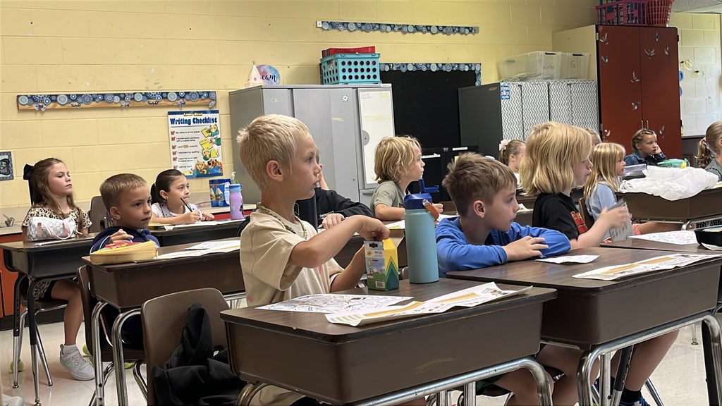 Children work at their desks on the first day of school. 