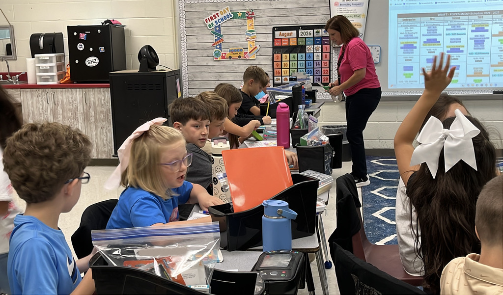 A teacher gives a group of students instructions on the first day of school.