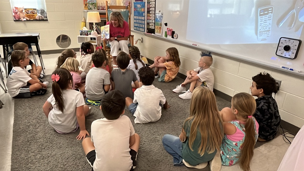 A teacher gives a group of students instructions on the first day of school.