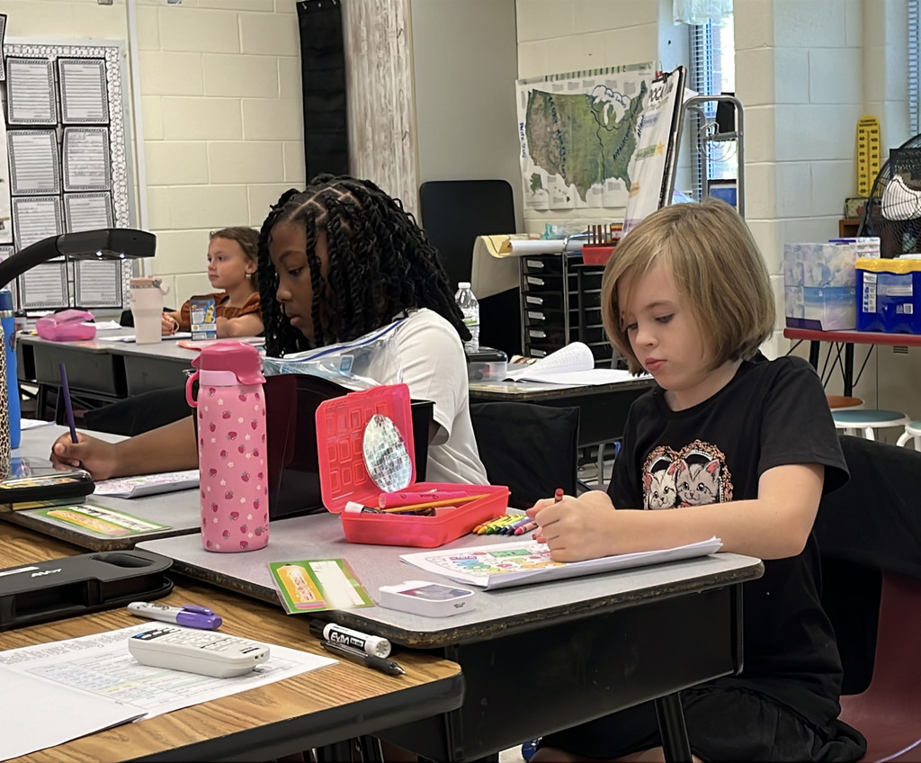 Students work at their desks on the first day of school.