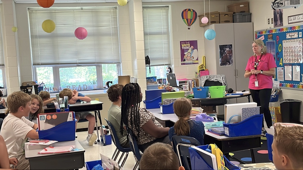 A teacher gives a group of students instructions on the first day of school.