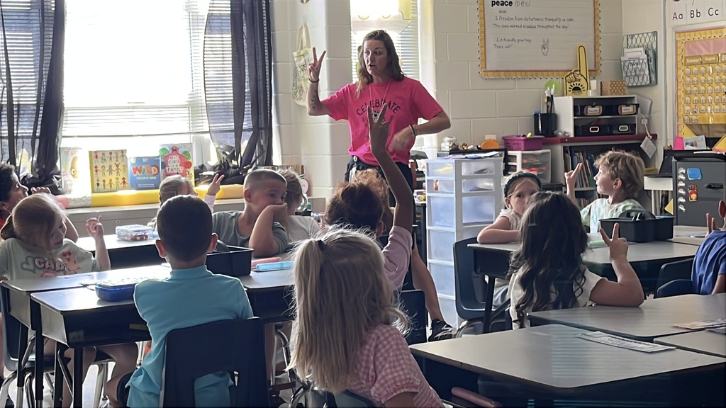 A teacher gives a group of students instructions on the first day of school.