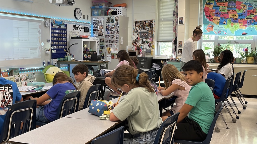 A teacher gives a group of students instructions on the first day of school.