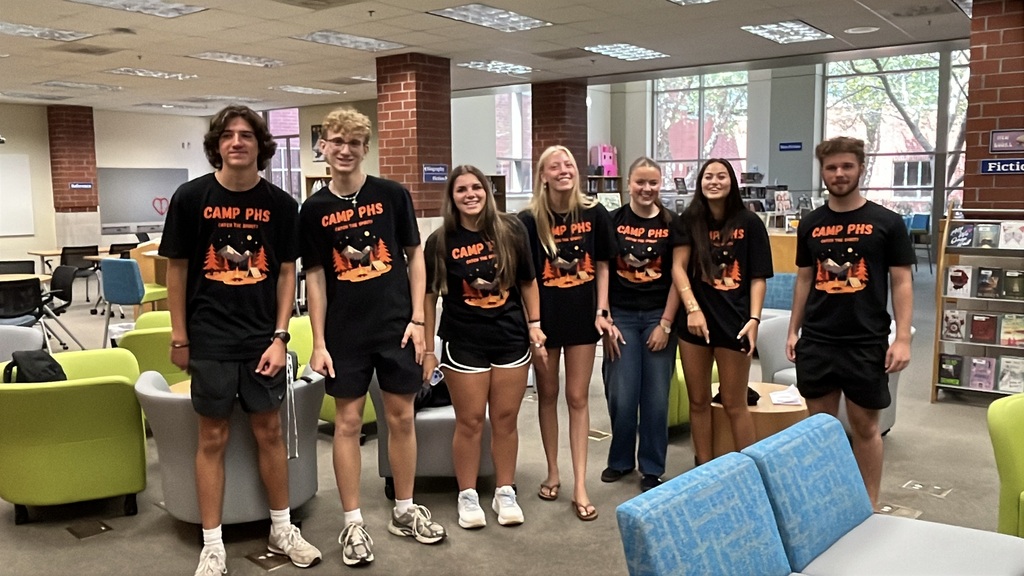 A group of students in matching shirts pose for a group photo.