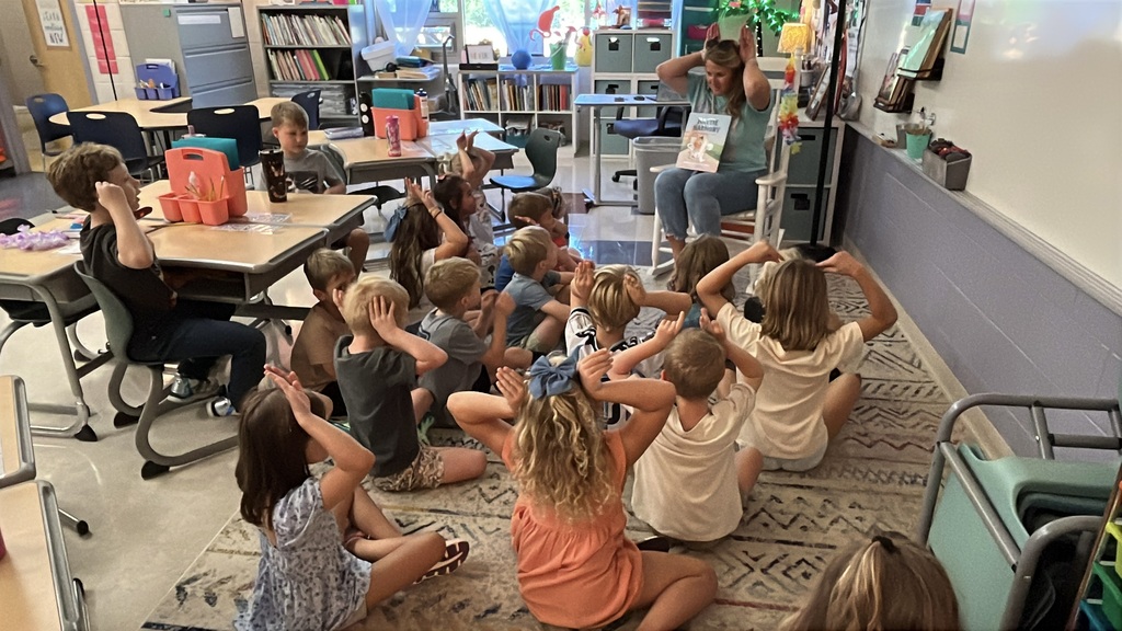 A teacher reads to a class of students on the first day of school.