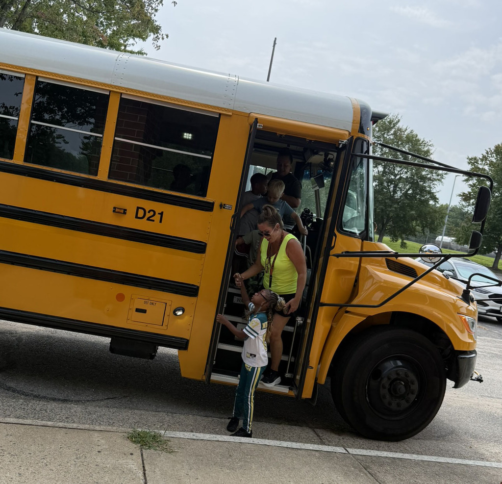 An adult and child exit a school bus.