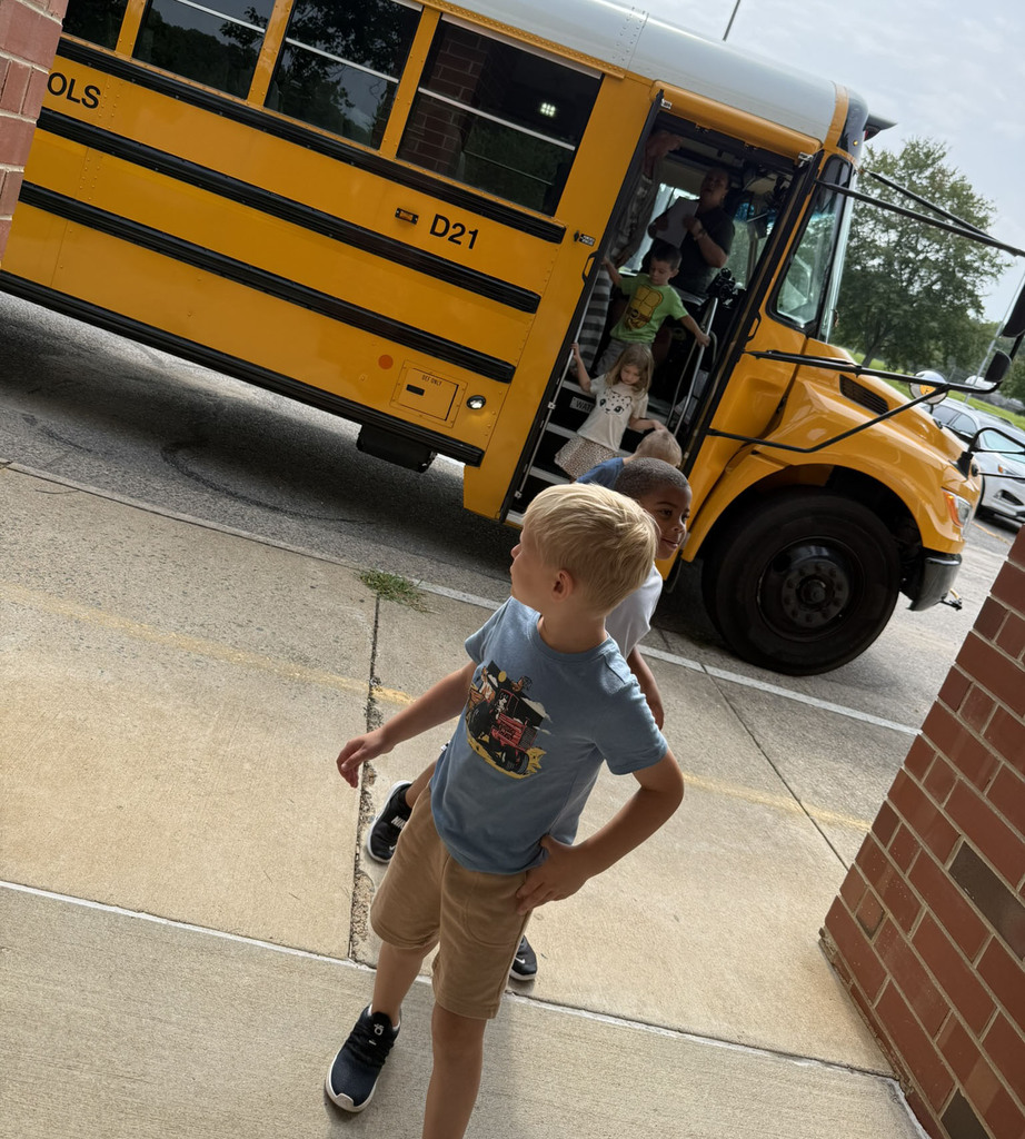 A line of children exit a school bus they just toured.