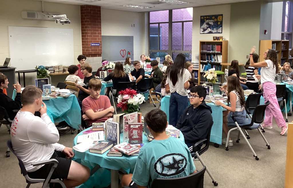 High school freshmen participate in a book tasting event in the school library.