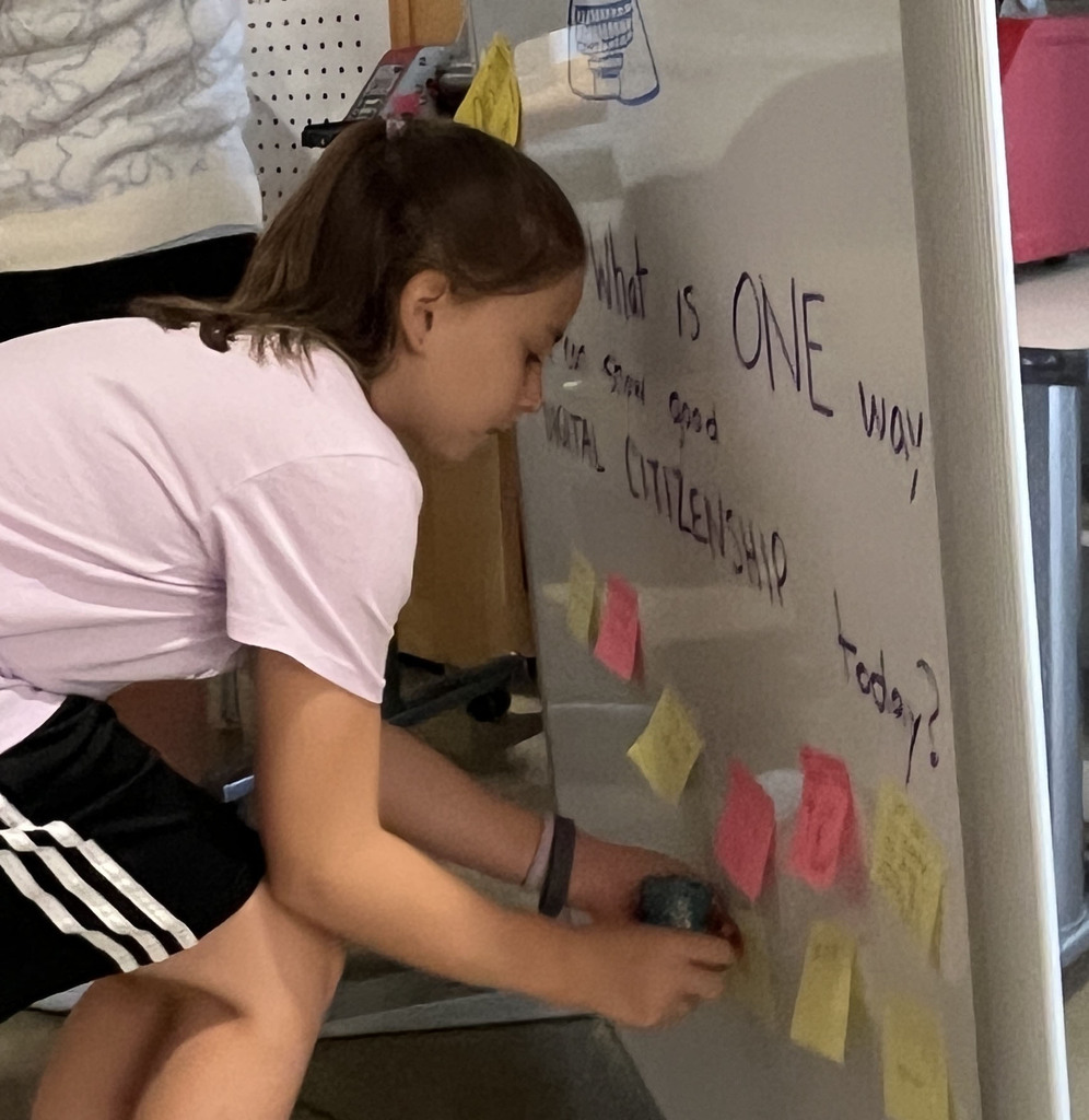 A student answers a question on a board prompting them to think about digital citizenship.