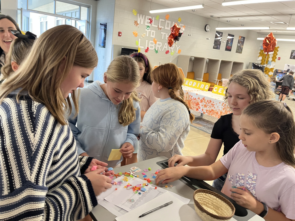 Students look through small plastic prizes to choose one as a prize for participating in an activity. 