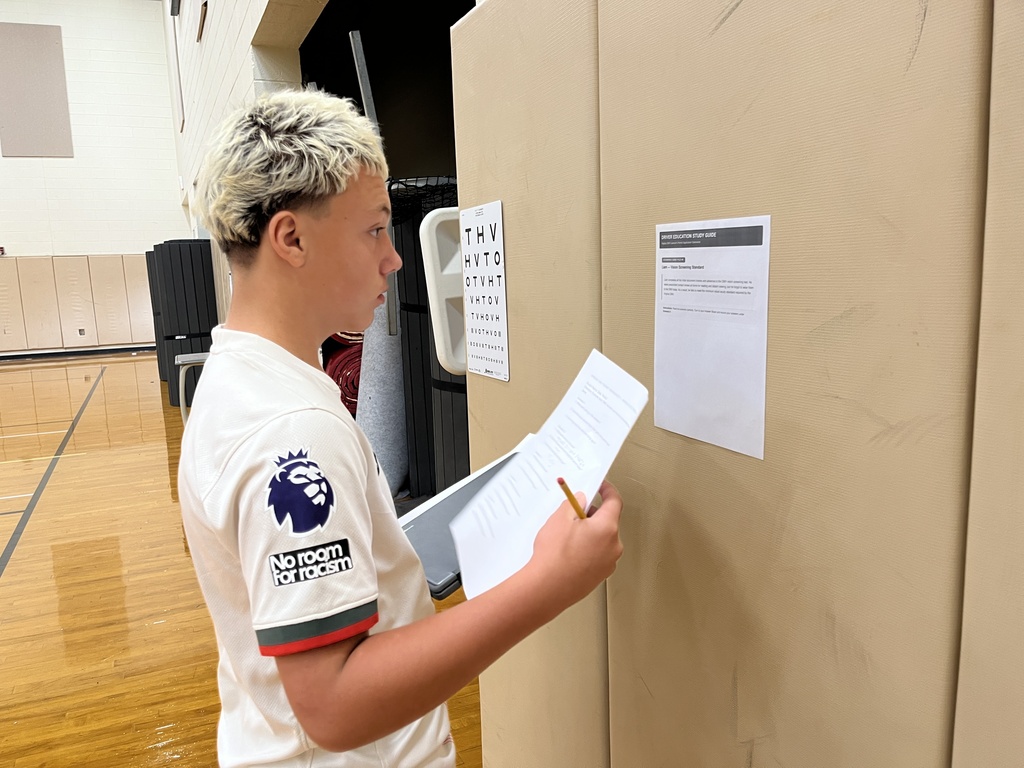 A student in drivers ed class participate in stations to help himlearn about the process of a DMV visit.