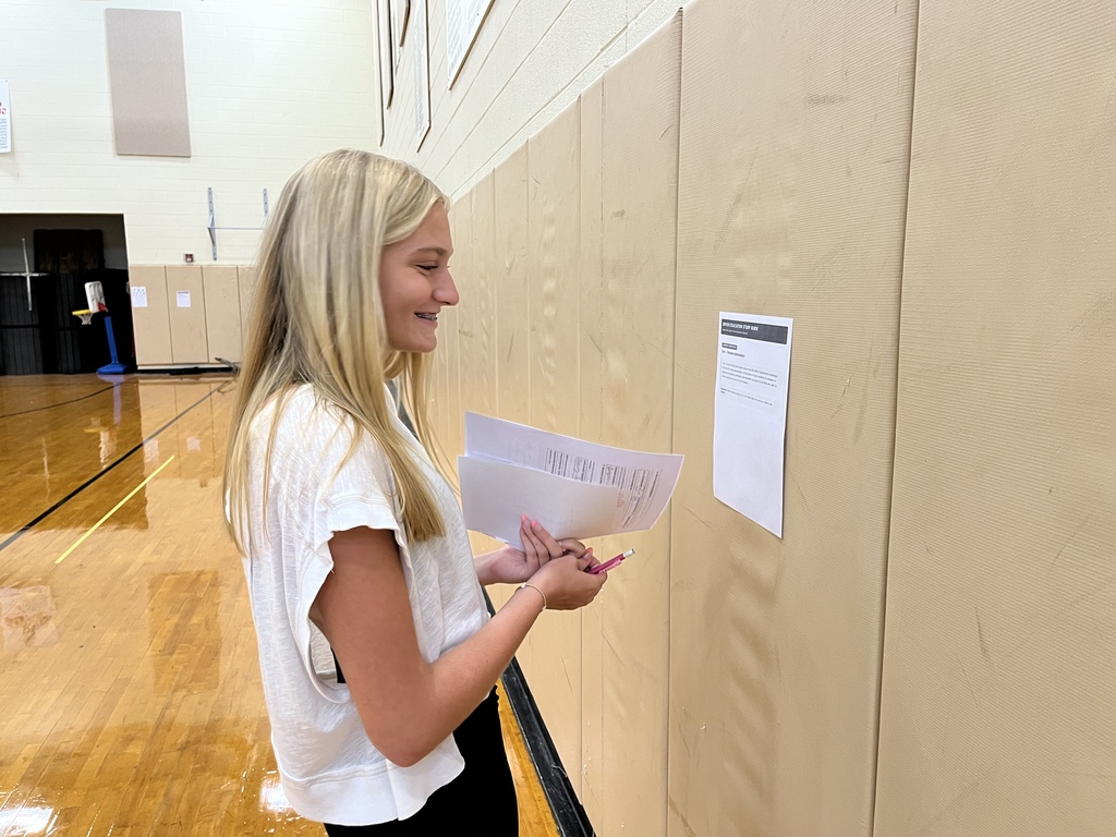 A student in drivers ed class participate in stations to help her  learn about the process of a DMV visit.