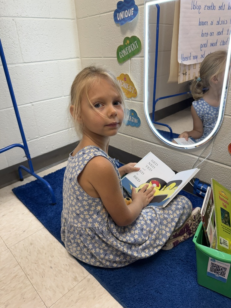 A first grader on the first day of school participates in a read to self activity.
