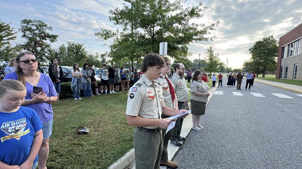 Scouting America members lead a 9/11 ceremony held in front of a middle school.