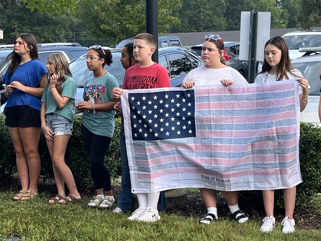 Students  listen during a 9/11 ceremony held in front of a middle school.