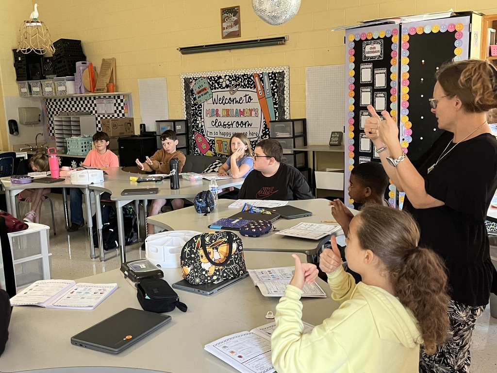 Fifth graders listen to a lesson from their teacher on the law of conservation of matter.