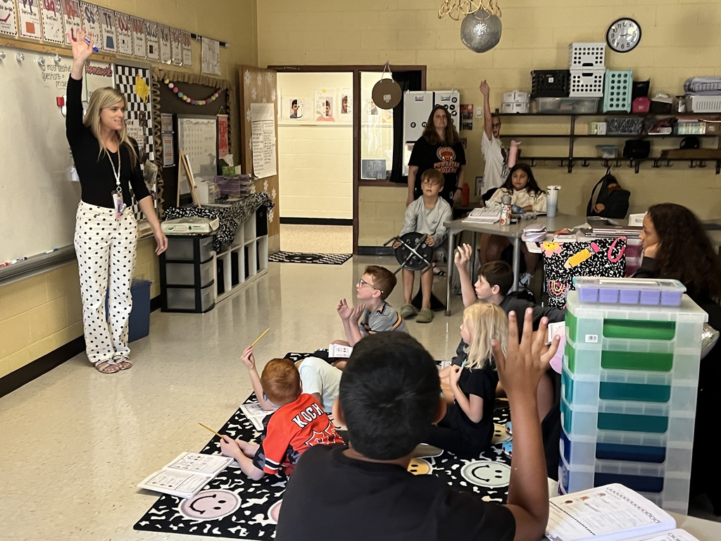 Fifth graders listen to a lesson from their teacher on the law of conservation of matter.