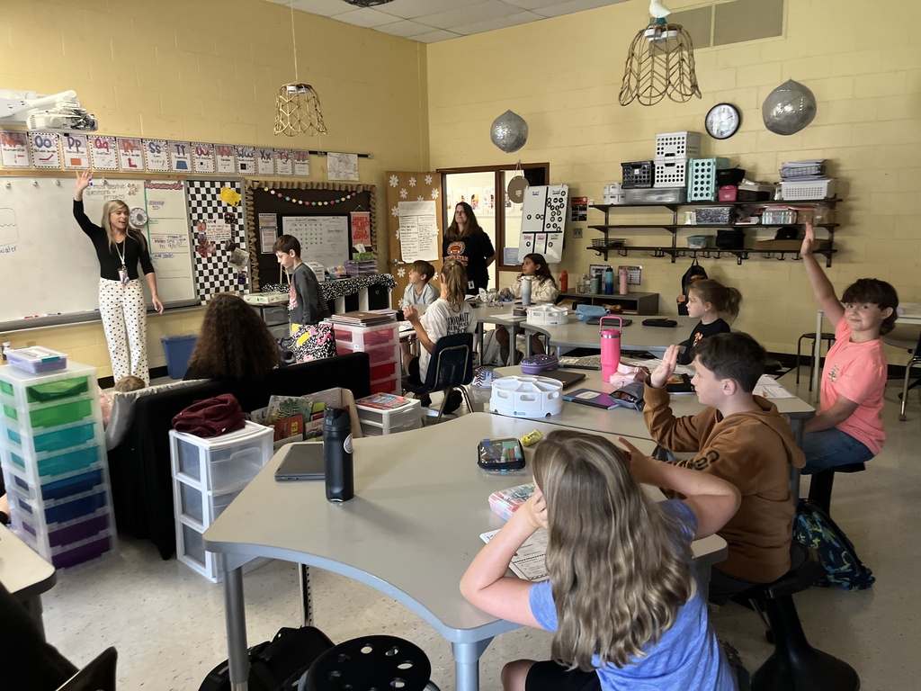 Fifth graders listen to a lesson from their teacher on the law of conservation of matter.