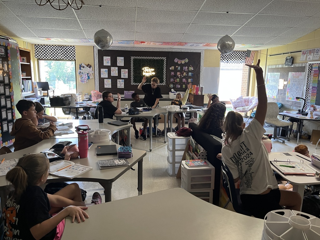 Fifth graders listen to a lesson from their teacher on the law of conservation of matter.