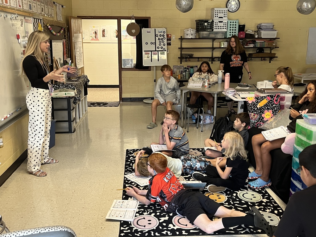 Fifth graders listen to a lesson from their teacher on the law of conservation of matter.