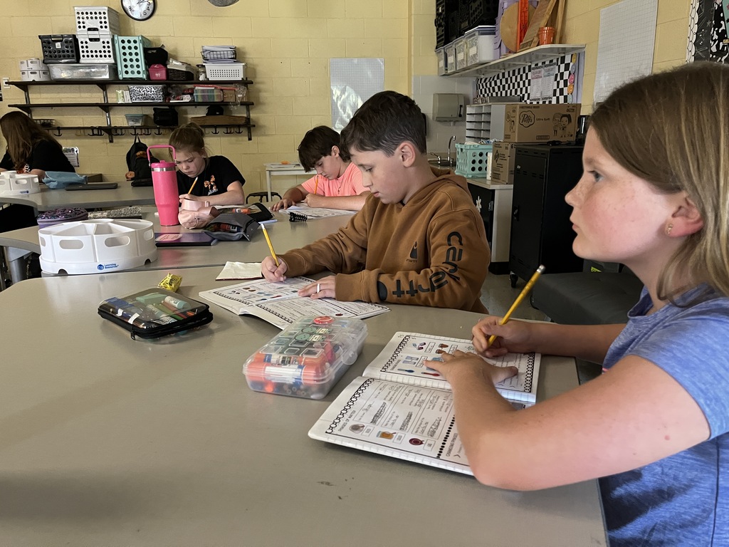 Fifth graders listen to a lesson on the law of conservation of matter.
