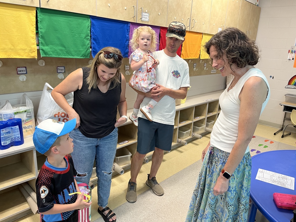 A teacher greets her new student and his family during a school open house. 