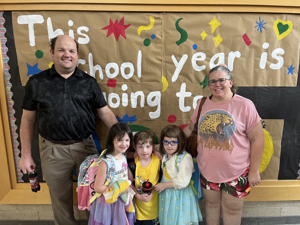 Two adults and three children pose for a photo at a school open house event. 