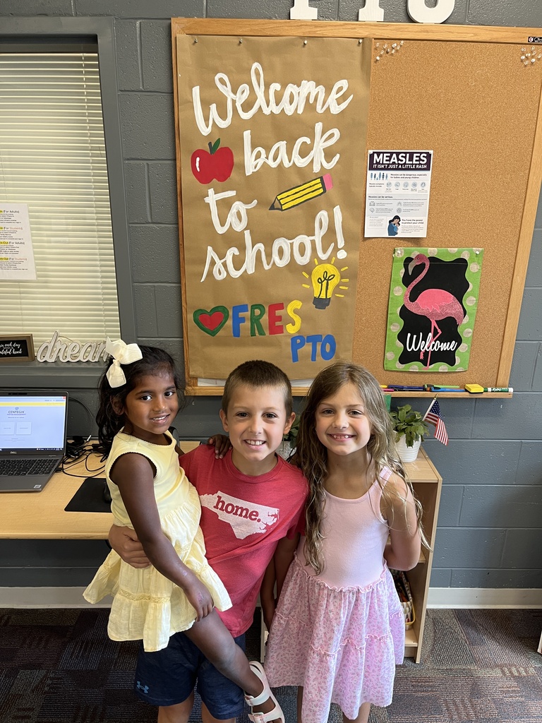 Three children pose for a photo at a school open house event. 