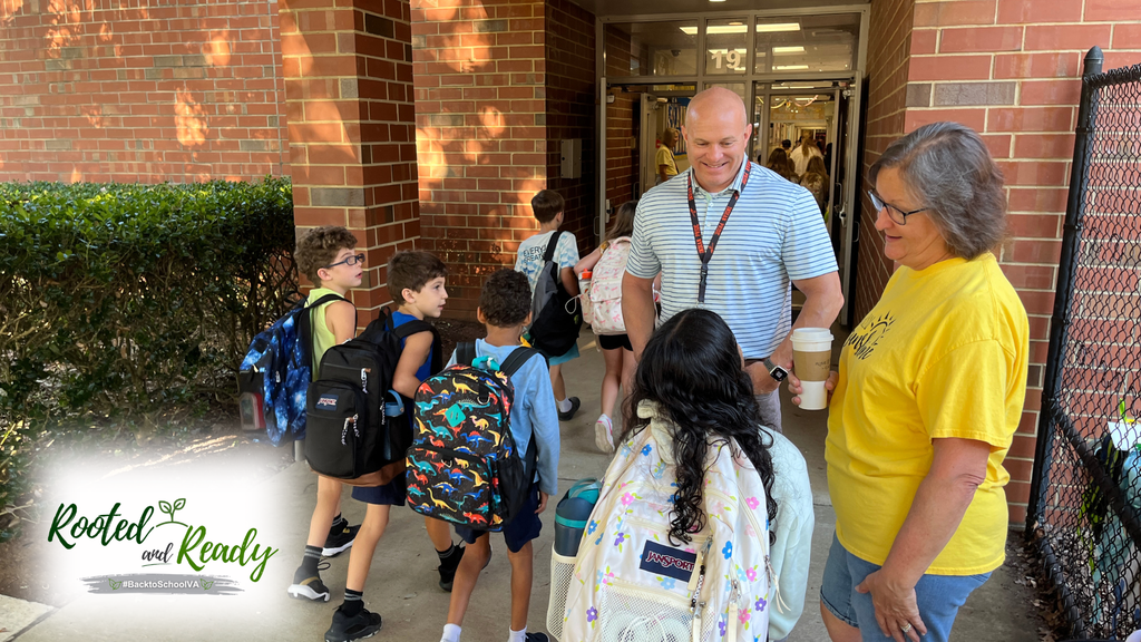 A school board member and staff member welcome students to school. Text embedded in photo: Rooted and Ready. 