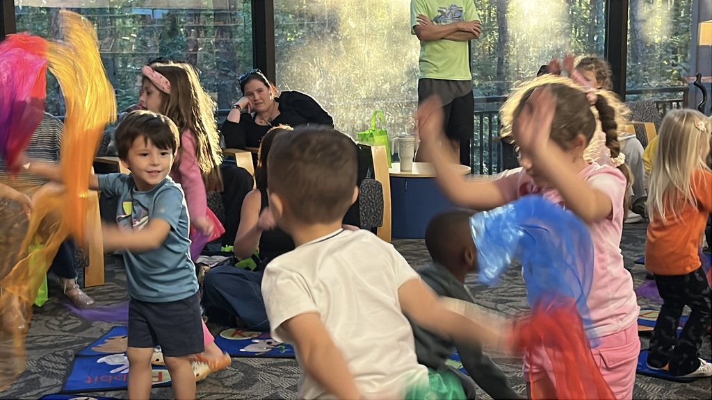 Children play play during a preschool literacy event at a library.