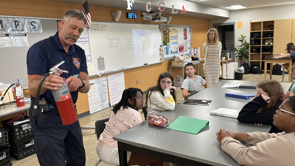 A firefighter talks to a family and consumer sciences class about fire extinguisher and fire safety.