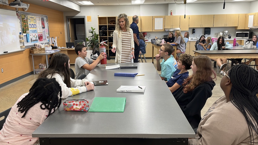 Students in a family and consumer sciences class pass around a fire extinguisher during a lesson on fire safety.
