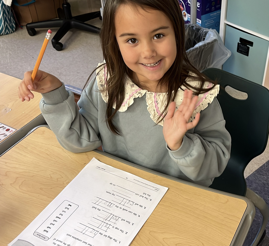 A student whose class is rotating to different language arts stations works on an assignment.