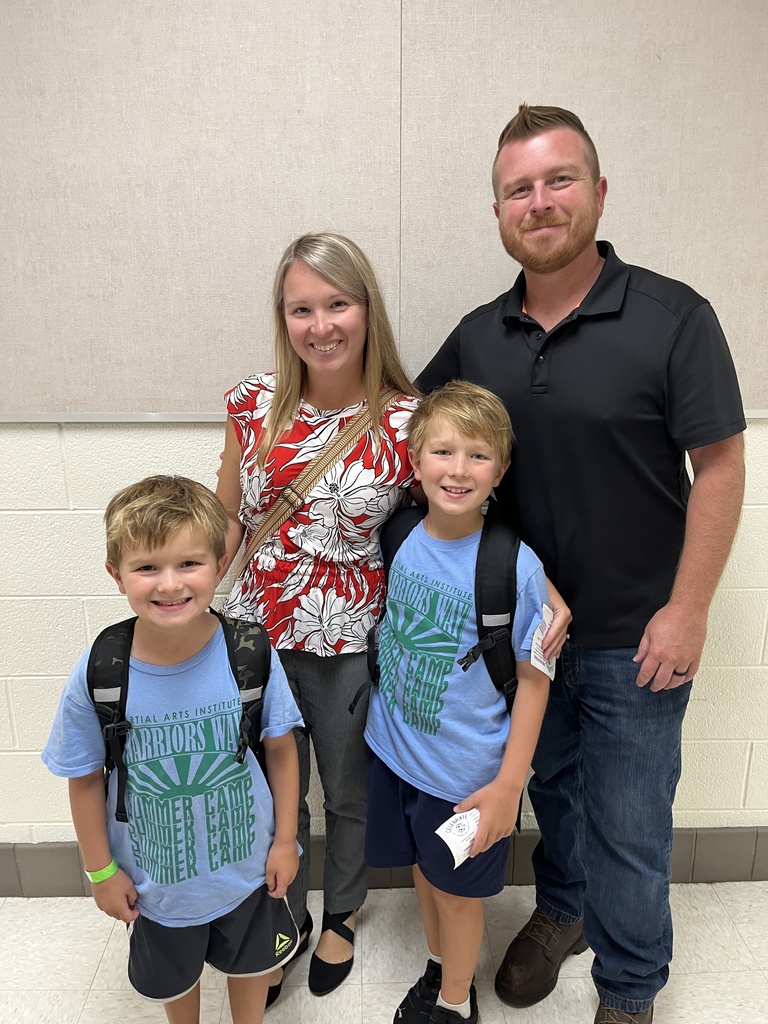 Two adults and two children pose for a photo at an elementary school open house. 