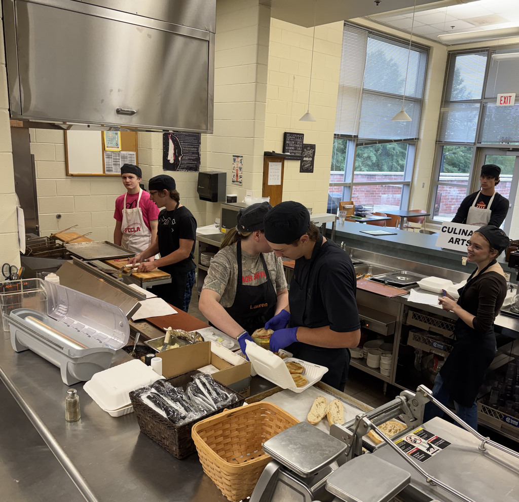 Culinary students prepare lunch in the kitchen of their student-run cafe, which is also their classroom.